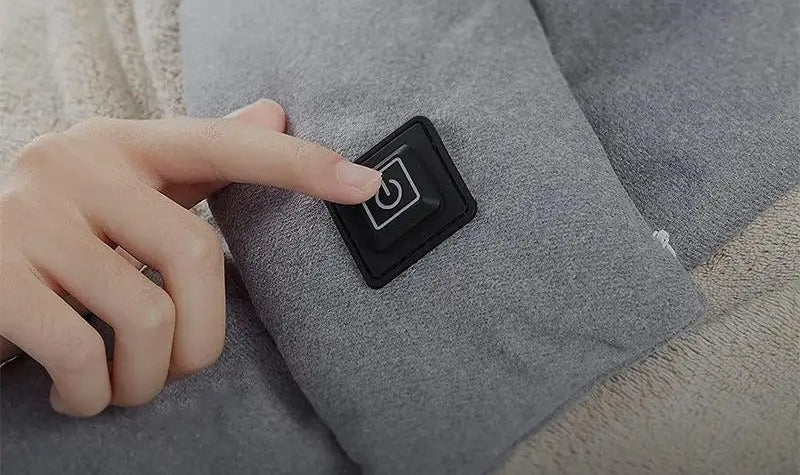 Finger pressing the button of the USB heated scarf